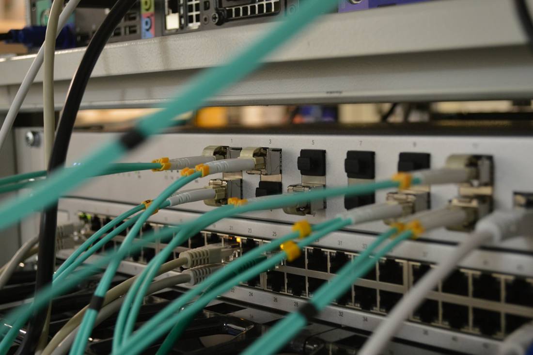 Fiber patch cables connected to rack-mounted network switches